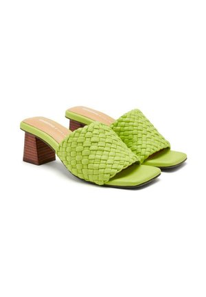 Des sandales à glissière tressées vertes avec des orteils carrés et un petit talon en bois. L'empeigne présente un design tressé texturé.