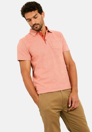 Poloshirt in hellem Korallenrot mit kontrastierendem rotem Kragen, kurzen Ärmeln und einer Brusttasche. Hergestellt aus einem strukturierten Stoff.