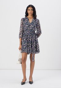 Rochie cu imprimeu floral, cu decolteu în V, mâneci lungi și talie strânsă. Materialul este subțire; culorile includ albastru închis, roz și alb.