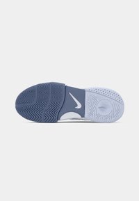 Såle av en sneakers med blå og hvit gummi, med fiskebens- og sirkulære gripe mønstre, samt en hvit Nike swoosh-logo i midten.