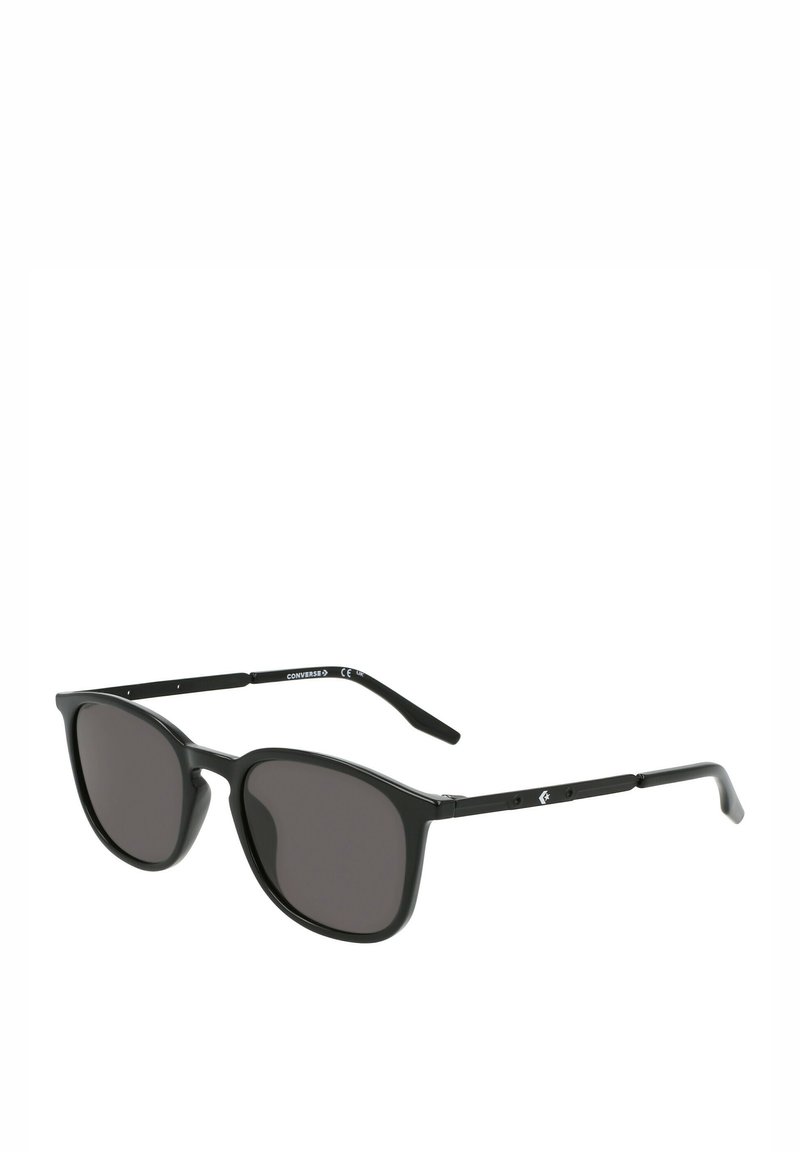 Occhiali da sole neri con lenti ovali, montatura in plastica e sottili aste in metallo nero. Le lenti sono di un grigio scuro con una sottile sfumatura.