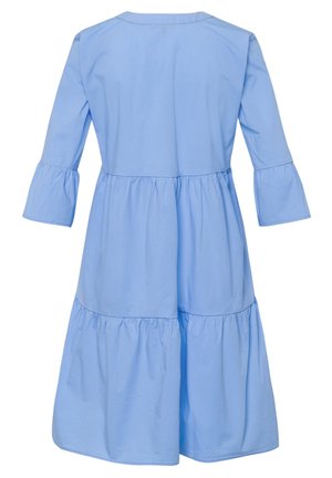Vestido azul claro en capas hasta la rodilla con mangas 3/4 y escote redondeado, mostrado desde atrás sobre un fondo blanco.