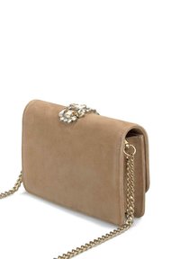 Bolso bandolera de ante beige con una correa de cadena dorada, que cuenta con un cierre decorativo de cristal en el frente y una forma rectangular compacta.