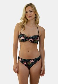 Ensemble de bikini floral avec un fond noir et des accents roses et verts. Le haut présente un design torsadé avec des bretelles réglables.