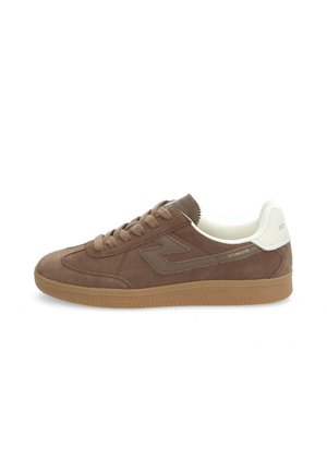 Brown suede sneaker with a textured upper, flat laces, and a contrasting white heel accent. Features a rubber sole and logo detail.