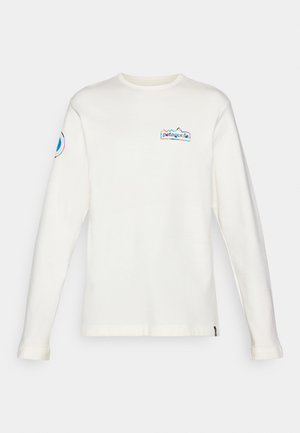 Weißes langärmliges Shirt aus weichem Baumwollstoff, mit einem mehrfarbigen Patagonia-Logo auf der Brust und einem kreisförmigen Logo am Ärmel.