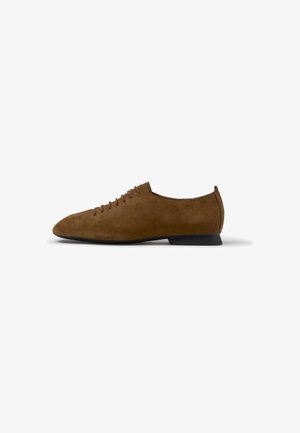 Scarpa bassa in camoscio marrone con lacci, tacco nero basso e punta arrotondata, vista di profilo su sfondo bianco.