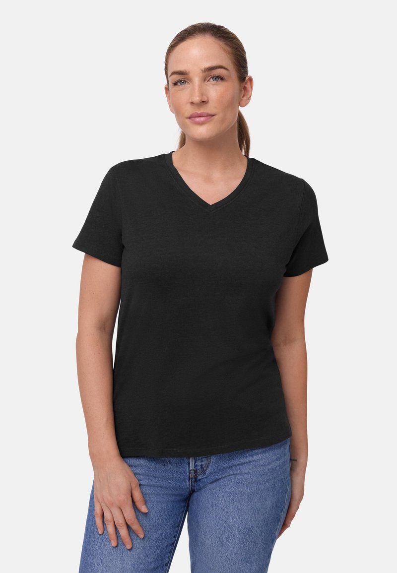 Svart V-ringad T-shirt i mjukt tyg, korta ärmar och avslappnad passform. Bärs med ljusblå jeans.