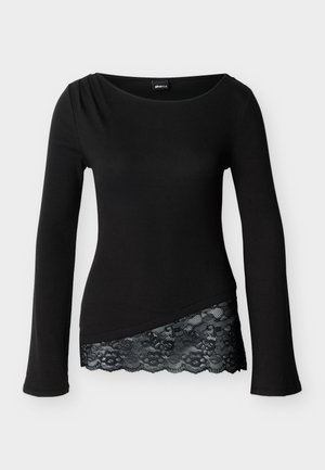 Fekete, hosszú ujjú felső bordázott mintával és ferde szegéllyel, fekete virágos csipkebetéttel.
