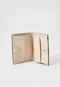 Pink leather wallet with a textured finish, featuring multiple card slots and a snap closure. Designed with a contrasting black edge.