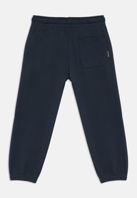 Pantalones de chándal azul marino con cintura y puños elásticos, que cuentan con un bolsillo trasero simple y una pequeña etiqueta "Replay" en el lado derecho.