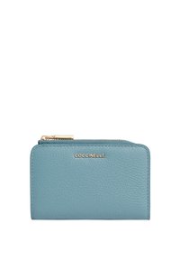 Klein rechthoekig teal leren portemonnee met gouden rits en "COCCINELLE" logo in het midden van de voorkant.