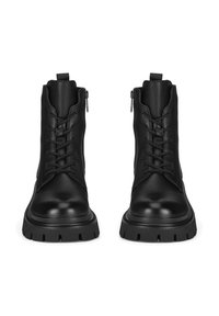 Czarne skórzane botki za kostkę z zapięciem na sznurowadła z przodu i suwakiem po boku. Gruba, wytrzymała podeszwa z głębokim bieżnikiem oraz zaokrąglony czubek.