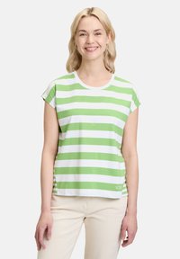 Zielono-biała w paski krótki rękaw t-shirt z okrągłym dekoltem i luźnym krojem, z małym logo na dolnym brzegu.