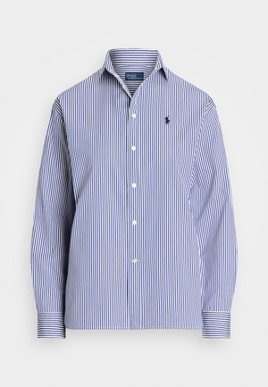 Chemise rayée bleue et blanche avec un col boutonné, dotée de manches longues et d'un petit logo sur la poitrine. Fabriquée en tissu coton.
