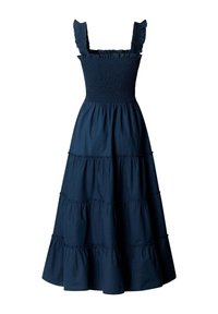 Tengerészkék ujjatlan ruha fodros pántokkal, ráncolt felsőrésszel és többrétegű, begyűrt szoknyával, amely térd alá ér.