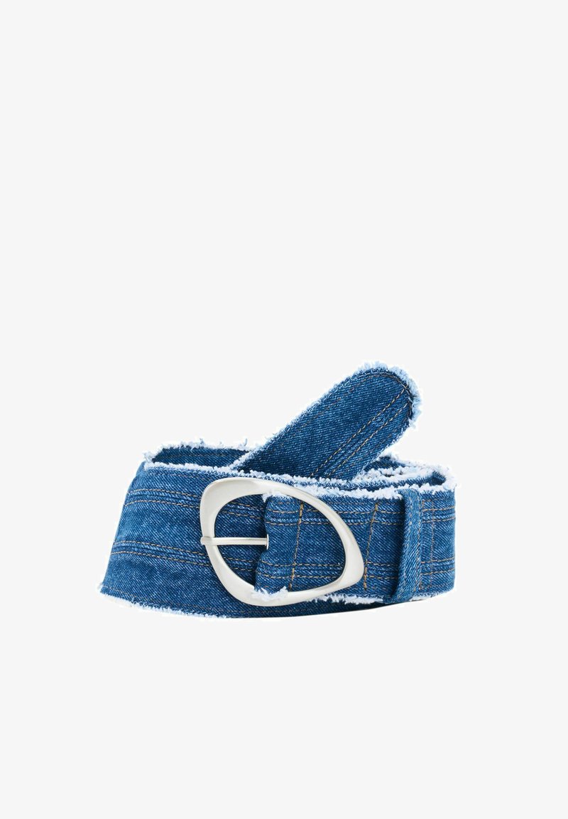 Curea din denim cu margini desfăcute și cusături vizibile, prevăzută cu o cataramă ovală argintie, rulată pe un fundal alb.