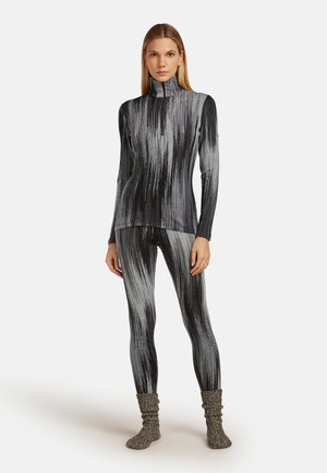 Zwart en grijs geblokt set met lange mouwen en leggings, met een hoge kraag en textuurstof. Aangevuld met zachte, gebreide beenwarmers.