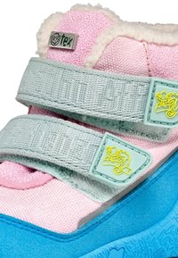 Kindersneakers met een roze textielen bovenkant, zachte vachtvoering, aqua klittenbandsluitingen en een blauwe rubberen zool met een gestructureerd ontwerp.
