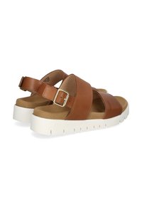 Bruine leren sandalen met kruislussen en verstelbare gespsluiting, voorzien van een gevoerde tan kleurige binnenzool en een witte, gestructureerde rubbere zool.