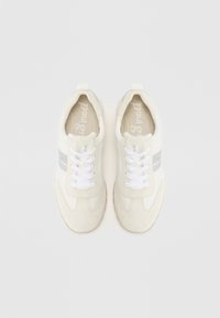 Hvite sneakers med semsket skinn og stoffmaterialer, med en sølvstripe, hvite lisser og teksturert gummisåle. Rund tådesign.