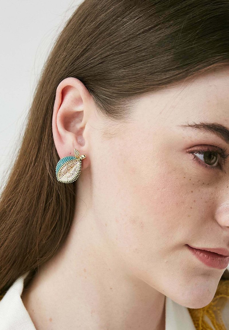 Örhängen formade som guldblad med akvamarin och klara rhinestones som detaljer. Designen har intrikata detaljer och en polerad yta.