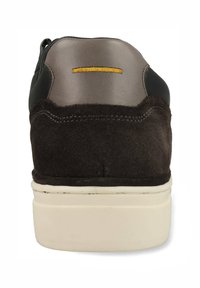 Schwarzer und brauner Sneaker mit glatter Lederkappe, Wildlederkörper und weißer Gummisohle. Gelbe Nähte an der Ferse verleihen Details.