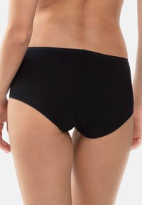 Culottes en coton noir avec une texture lisse, présentant une coupe taille moyenne et une ceinture élastique. Les bords sont cousus pour plus de durabilité.