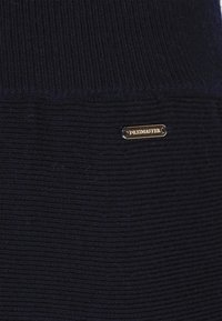 Marineblauer gestrickter Pullover mit einem gerippten Muster und einem kleinen Metall-Logoschild mit "DREITMASTER" auf der Vorderseite.