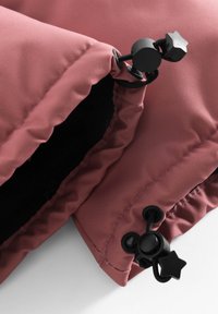 Rosa vadderad tyg med en ribbad textur, med svart hårdvara och en stjärnformad dragkrok. Inredningen är svart.