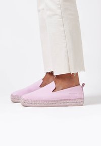 Espadrillas rosa chiaro con tomaia in tessuto liscio, lati intagliati e suole in juta intrecciata. Presentano un marchio sottile sul lato.