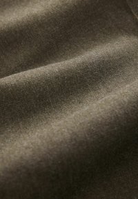 Olivgrüner Stoff mit einer weichen, glatten Textur, der sanfte Falten und subtile Variationen in Farbton und Licht zeigt und Tiefe suggeriert.