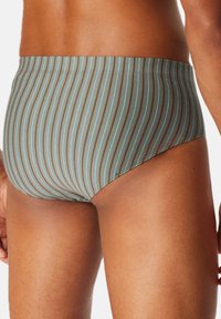 Gestreifte Swim-Briefs in einem gedämpften Blaugrün mit feinen braunen Streifen, ausgestattet mit einem nahtlosen Bund und einem enganliegenden Design für hohen Tragekomfort.