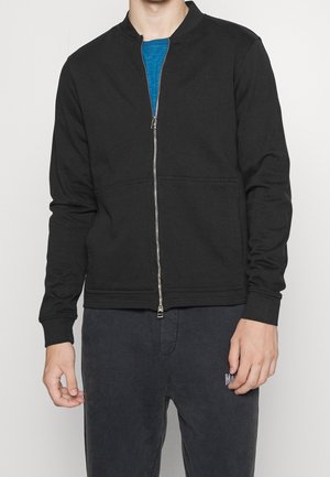 Schwarze, durchgehende Sportjacke mit Stehkragen, langen Ärmeln und zwei Fronttaschen. Hergestellt aus weichem Stoff mit glatter Textur.