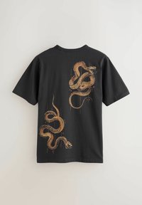 Must lühikeste varrukatega T-särk, millel on seljal kaks keerduvat, detailselt joonistatud pruuni madu, asetatud ülemisele ja alumisele paremale poole.