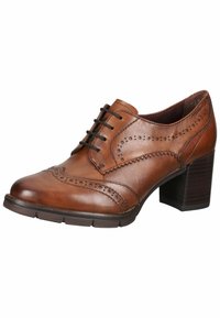 Hnědá kožená vyvýšená bota s dekorativními brogue perforacemi, kulatou špičkou a černými tkaničkami. Disponuje vrstveným podpatkem a texturovanou podešví.