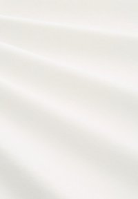 Witte katoenen stof met een gladde textuur, met subtiele kreukels en plooien. Het oppervlak heeft een uniforme kleur zonder patronen of accenten.