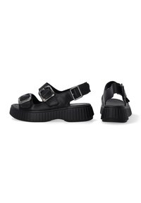 Zwarte sandalen met twee verstelbare gespen, open achterkant en dikke geribbelde zool. Gemaakt van synthetisch materiaal met een gladde textuur.