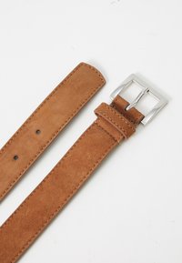 Cintura in suede marrone con fibbia in metallo argentato. Presenta una texture liscia, cuciture ordinate e cinque fori di regolazione lungo la sua lunghezza.