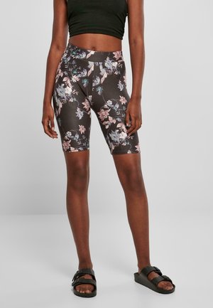 Zwarte fietsbroek met bloemenprint van rekbaar materiaal, voorzien van roze en blauwe bloemenaccenten, hoge tailleband en lengte tot halverwege de bovenbenen.
