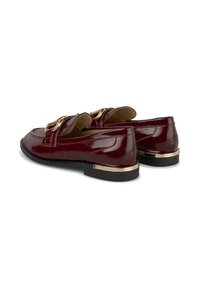 Burgundy patent leather loafers with a smooth texture, featuring a gold-tone hardware accent and a low black sole. Classic design.
