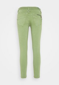 Skinny jeans in light green denim, featuring back pockets and a small zipper detail. Smooth texture with minimal stitching accents.