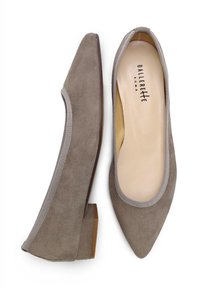 Mocasines de ante grises con puntera puntiaguda y un tacón bajo, que presentan un borde texturizado gris alrededor de la abertura y un forro interior suave.