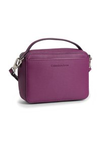 Mała prostokątna fioletowa torba crossbody z teksturowaną powierzchnią, górnym uchwytem, srebrnymi zapięciami i logo Calvin Klein Jeans z przodu.