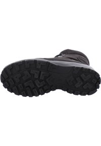 Suola di stivale in suede nero con battistrada in gomma rugged che presenta vari motivi geometrici per aderenza e durata.