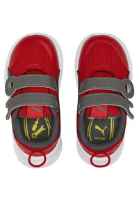 Červené a šedé dětské tenisky s dvojitými suchými zipy, bílé podrážky a žluté logo Puma a nářadí na tmavě šedých stélkách.