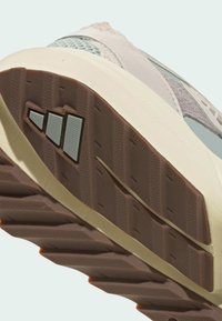 Ľahké tenisky s textúrovanou gumovou podrážkou v hnedom a smotanovom farebnom prevedení. Horné materiály zahŕňajú šedé a jemne modré akcenty.