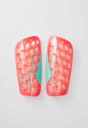 Red plastic soccer shin guards with perforated design, featuring light blue accents and embossed branding. Labeled 'L' and 'R' for left and right.