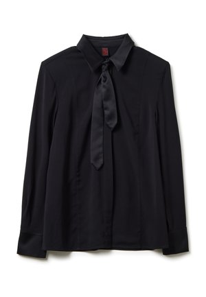 Blouse noire à manches longues avec col pointu et détail de cravate en satin, posée à plat sur un fond blanc.