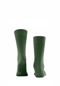 Calzini in cotone verde con un design a coste sul polsino, texture liscia e un sottile dettaglio del logo alla caviglia, che mostrano una forma semplice e classica.